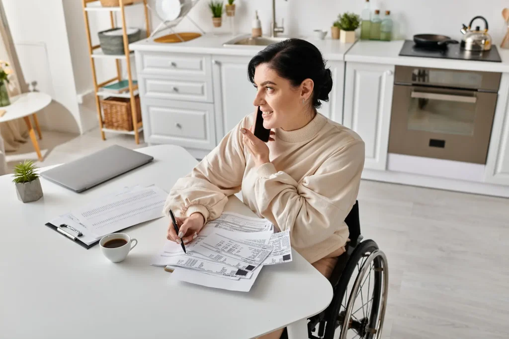Woman in wheelchair in her living room using the phone to contact coordination of care services
